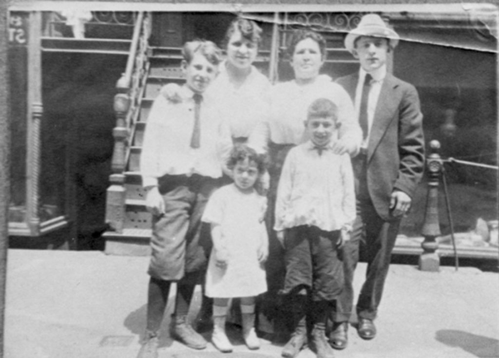 Black and white photo of the Rogarshevsky family standing in front of the steps of 97 Orchard Street