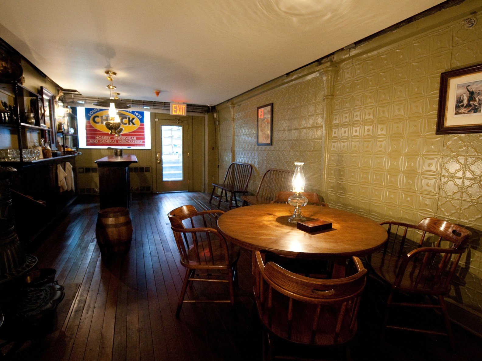 Schneider saloon at a different angle showing a lamp on a table with 4 seats and a decorative tile-patterned wall behind it