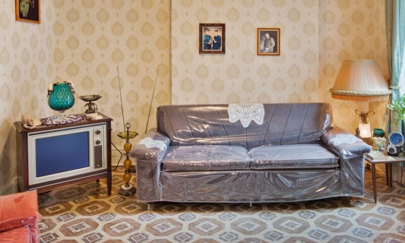 Plastic covered couch and television in a recreated 1960s tenement living room.