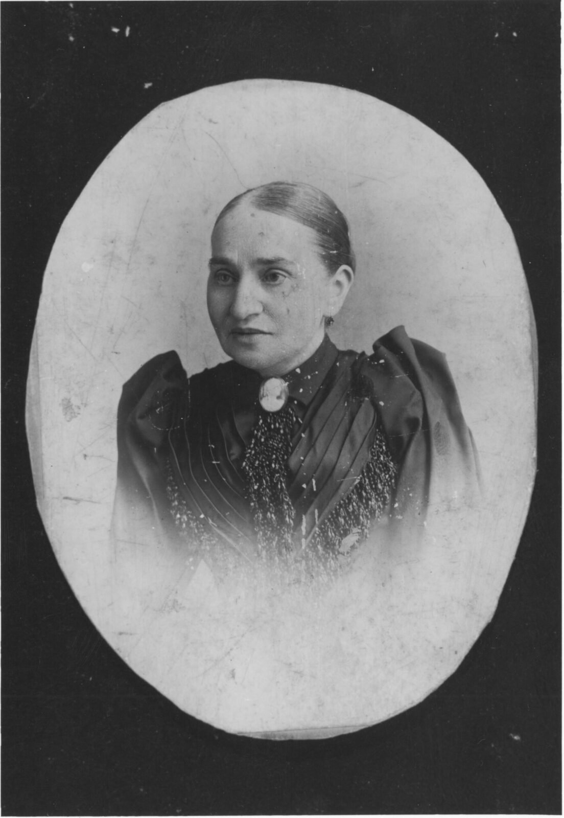 An oval photographic portait of 97 Orchard tenent Nathalie Gumpertz with hair pulled back, wearing an elaborate dress.