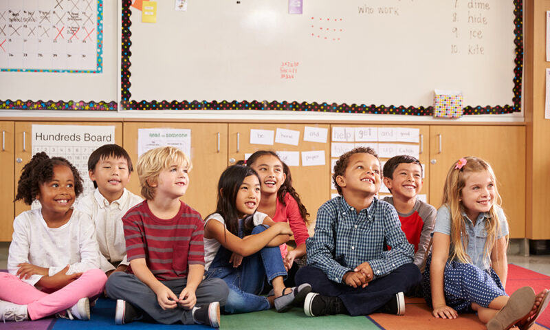 Elementary school kids sitting on classroom floor