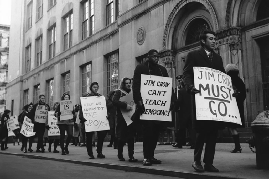 Protesters holding signs against Jim Crow