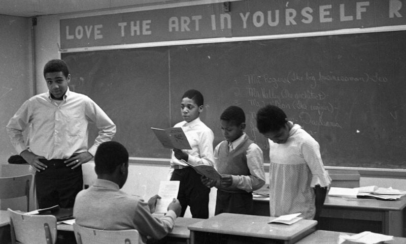 Black and white photo of black students in classroom standing in the front of the class.