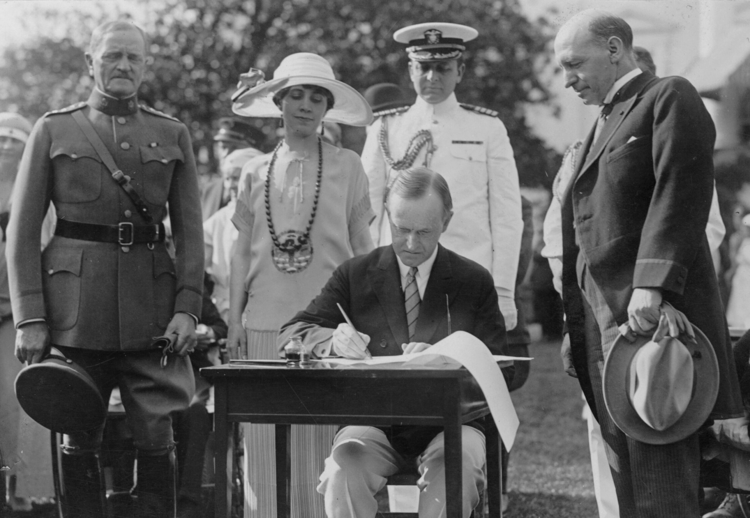 President Calvin Coolidge signs the Immigration Act on the White House South Lawn along with appropriation bills for the Veterans Bureau, Library of Congress